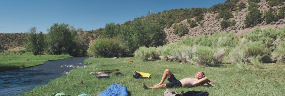 Sterling Noren doing laundry by river on motorcycle trip