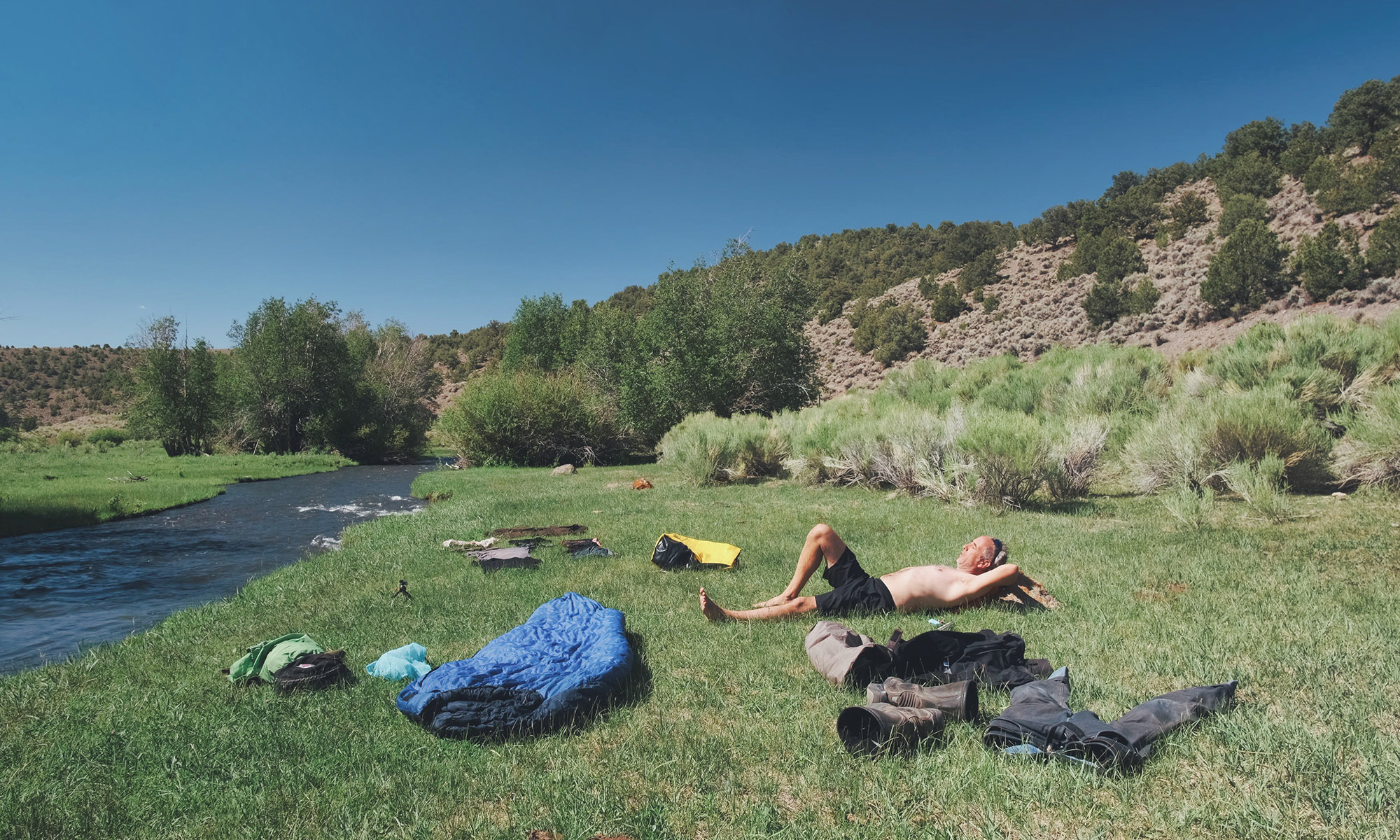 Sterling Noren doing laundry by river on motorcycle trip