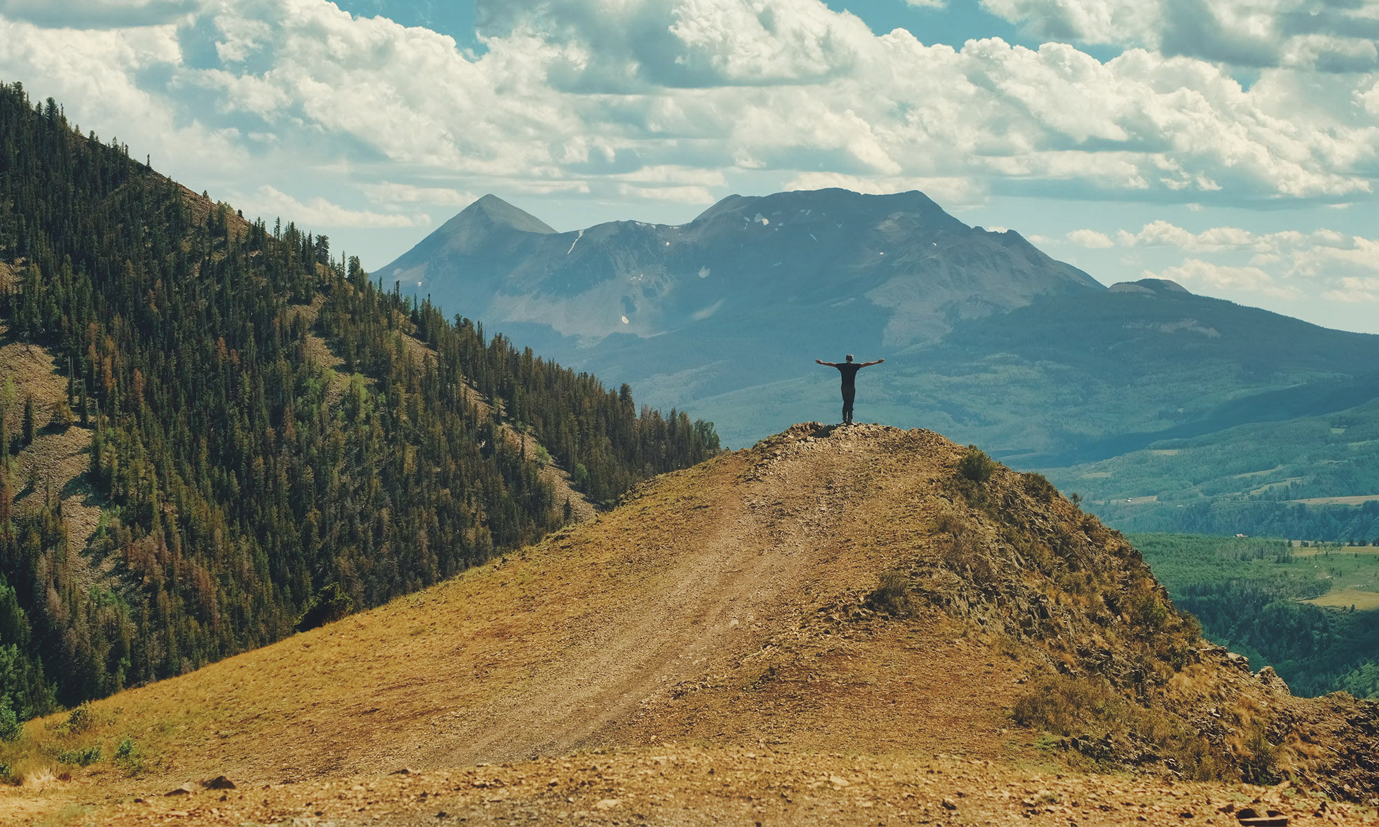 Man standing on hilltop in Colorado Last Dollar Road