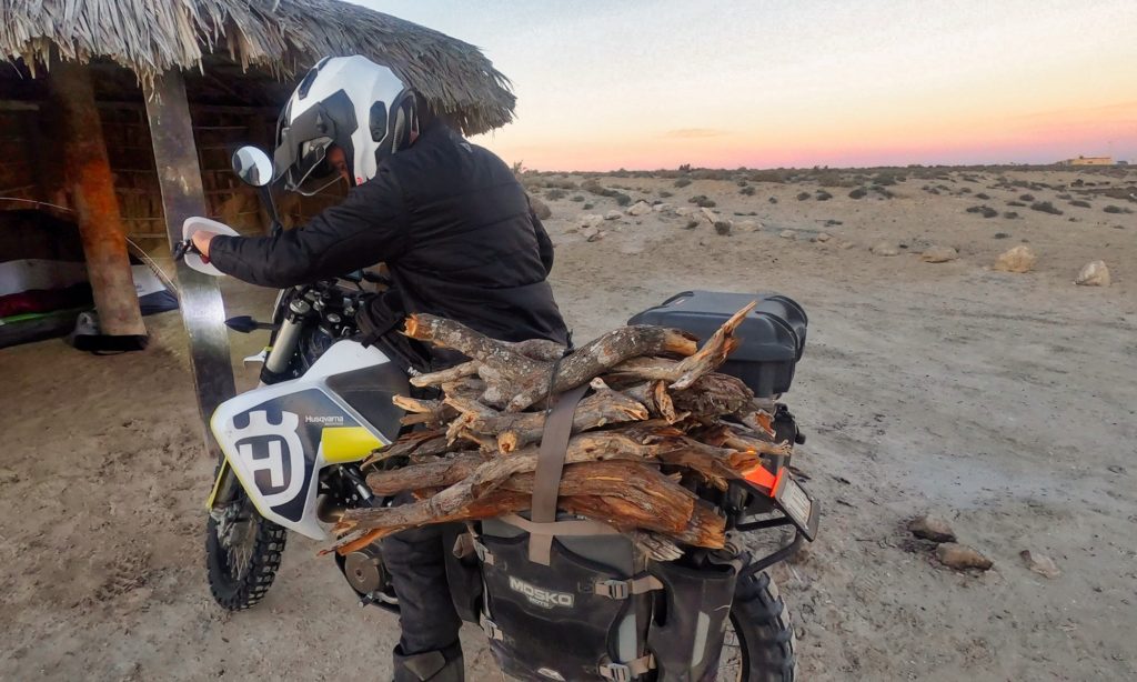Sterling carrying firewood on Husqvarna motorcycle