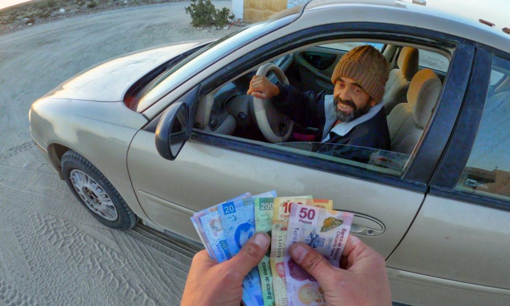 Buying firewood from vendors in a car with Mexican pesos in Baja California