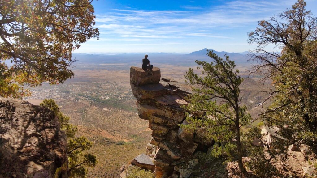 Sterling Noren perched on a rock high above the desert