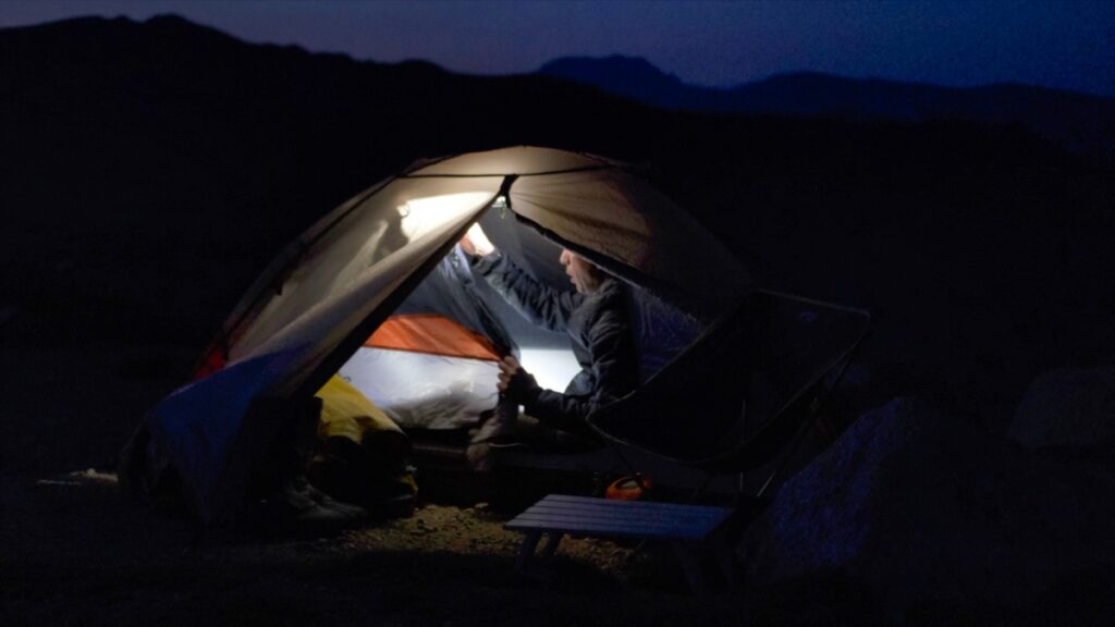 Turning off light in tent at night in Rollins Pass in Colorado