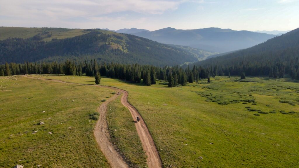 Lone motorcycle riding dirt road on Ptarmigan Pass Colorado