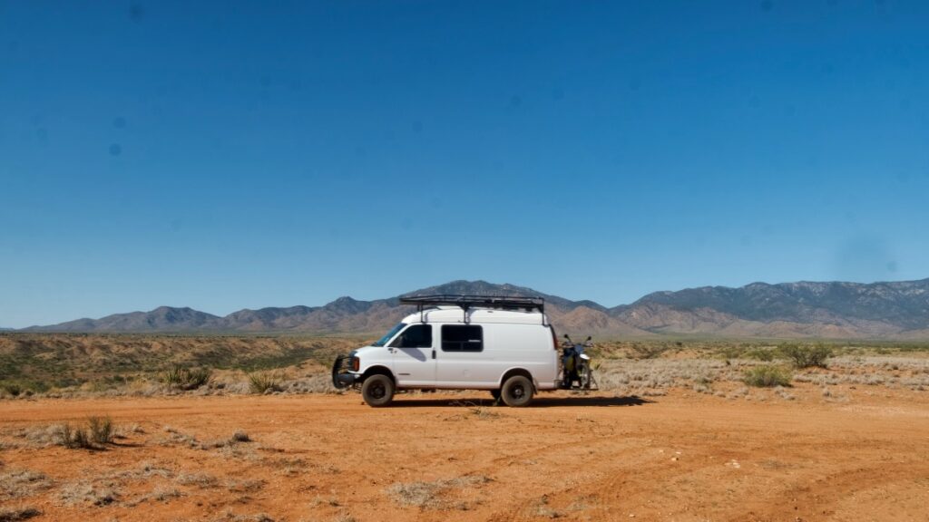 Chevrolet 4x4 van with motorcycle on rear bumper