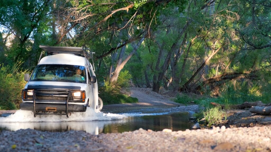 Chevrolet 4x4 van driving through creek in Arivaipa Canyon