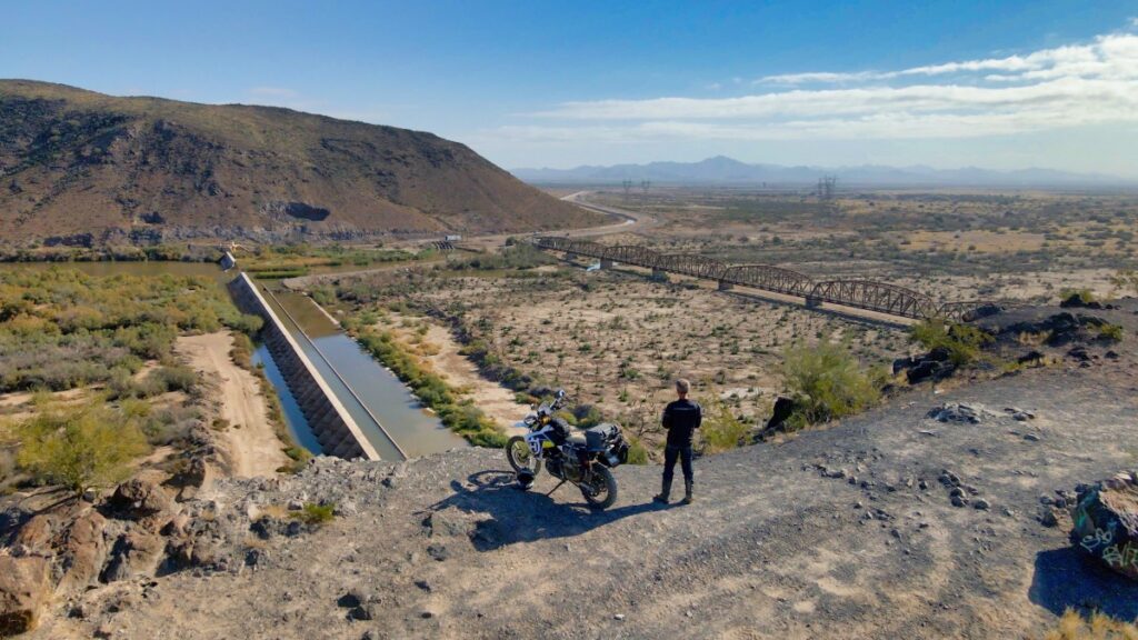 Sterling Noren and his motorcycle parked on a hill overlooking Gillespie Dam and bridge Gila River Arizona