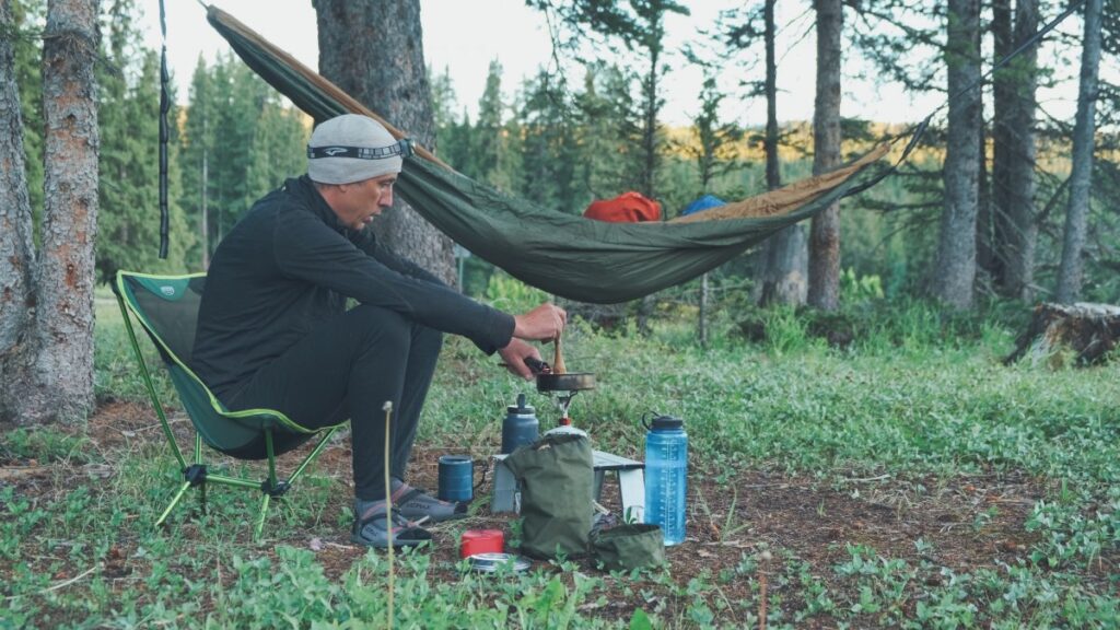 Sterling Noren cooking on camp stove with hammock