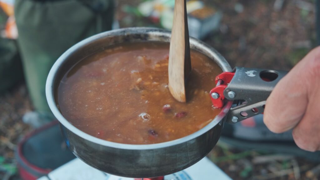 cooking chili in pot on camp stove
